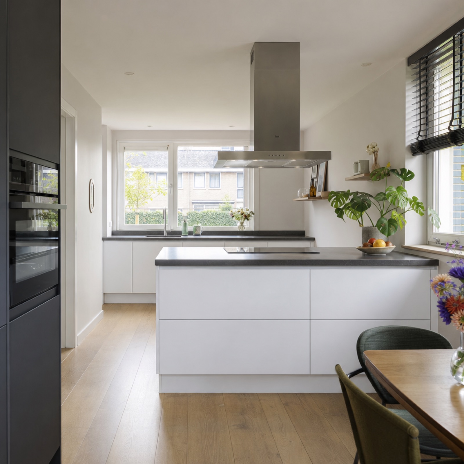 Lichte keuken met wit kookeiland en houten vloer