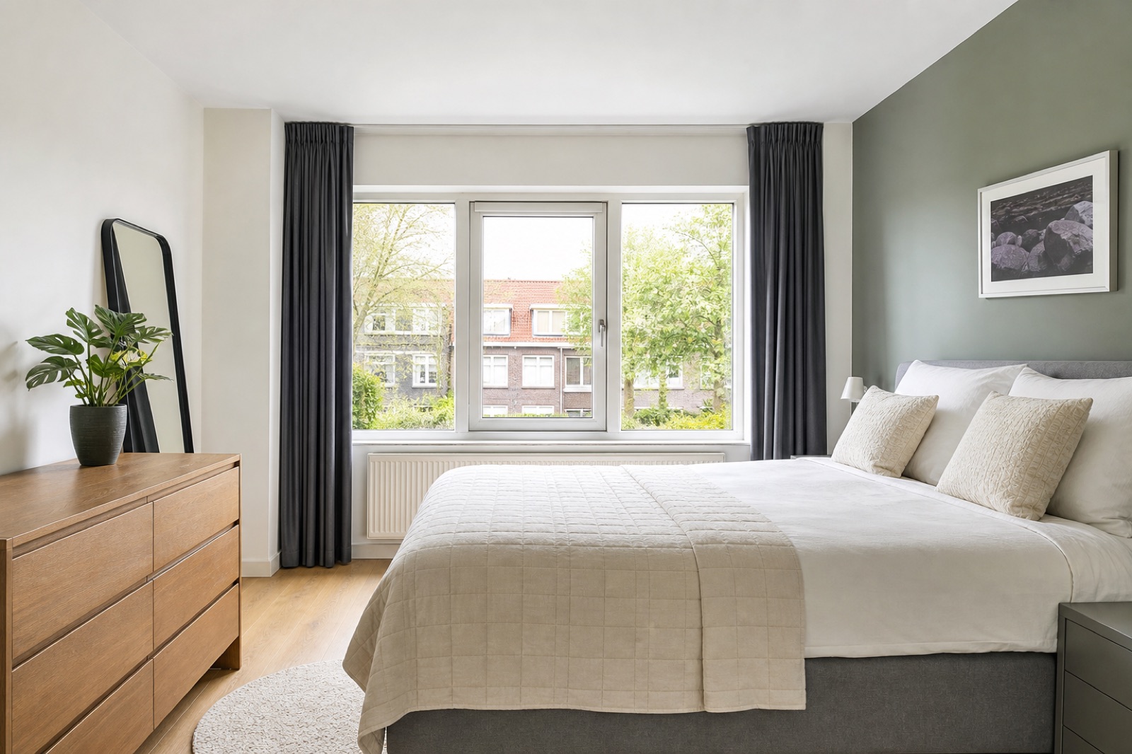 Lichte slaapkamer met een opgemaakt bed voor een groot raam
